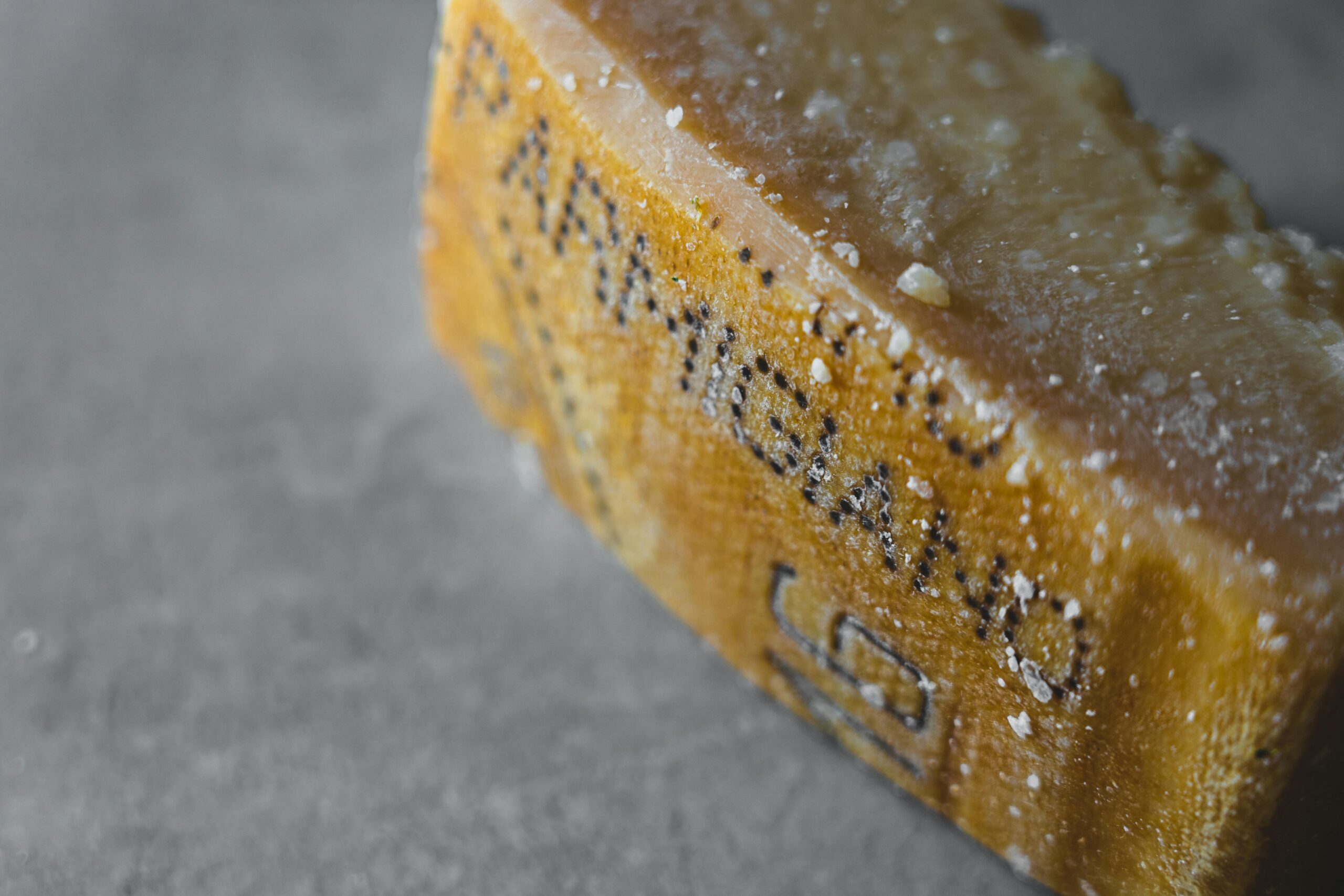 Detailed shot of Parmigiano Reggiano cheese showcasing its textured and aged surface.